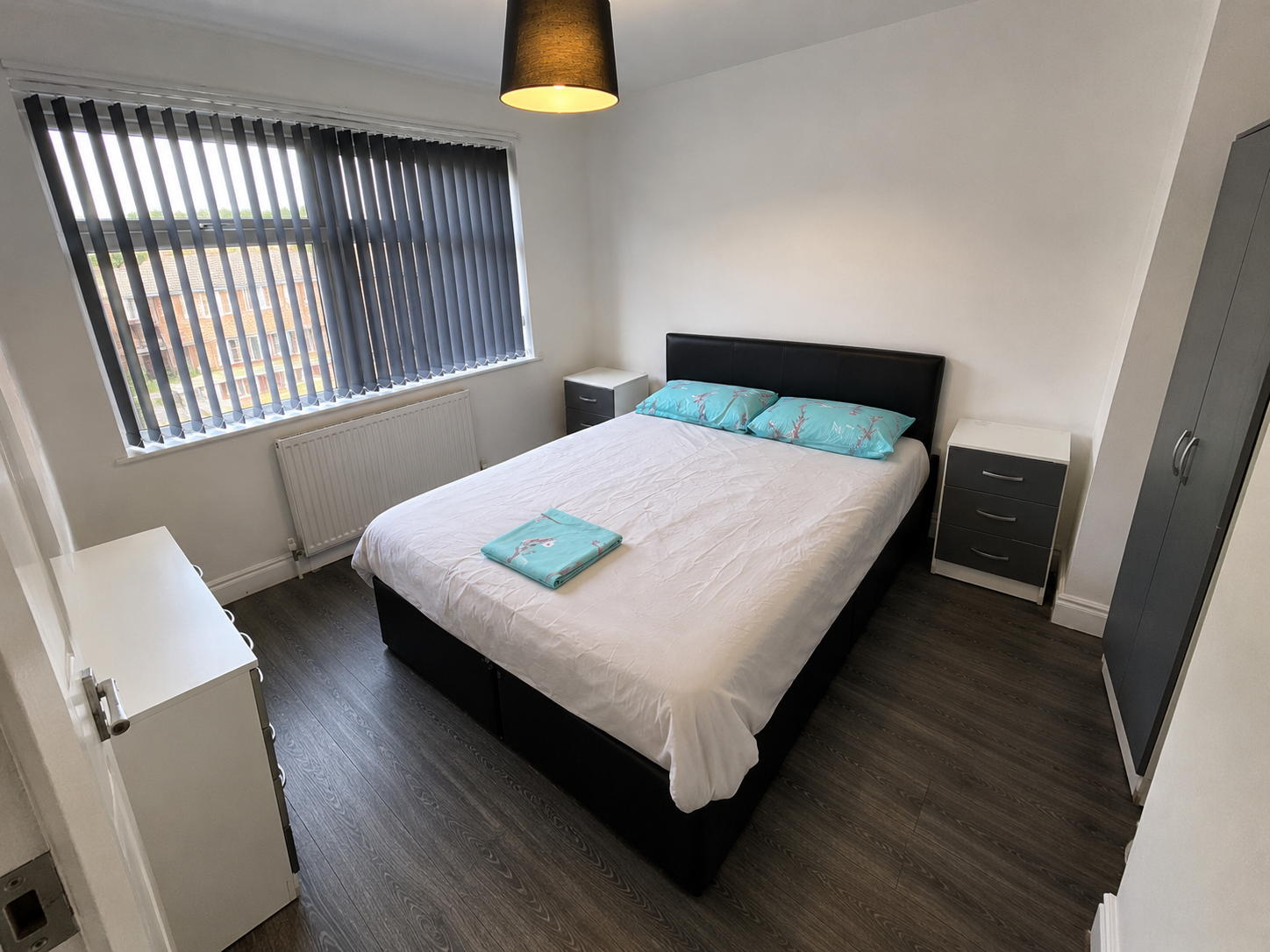Kings Norton – Room 2: second view of the double bed beside the window and wardrobe